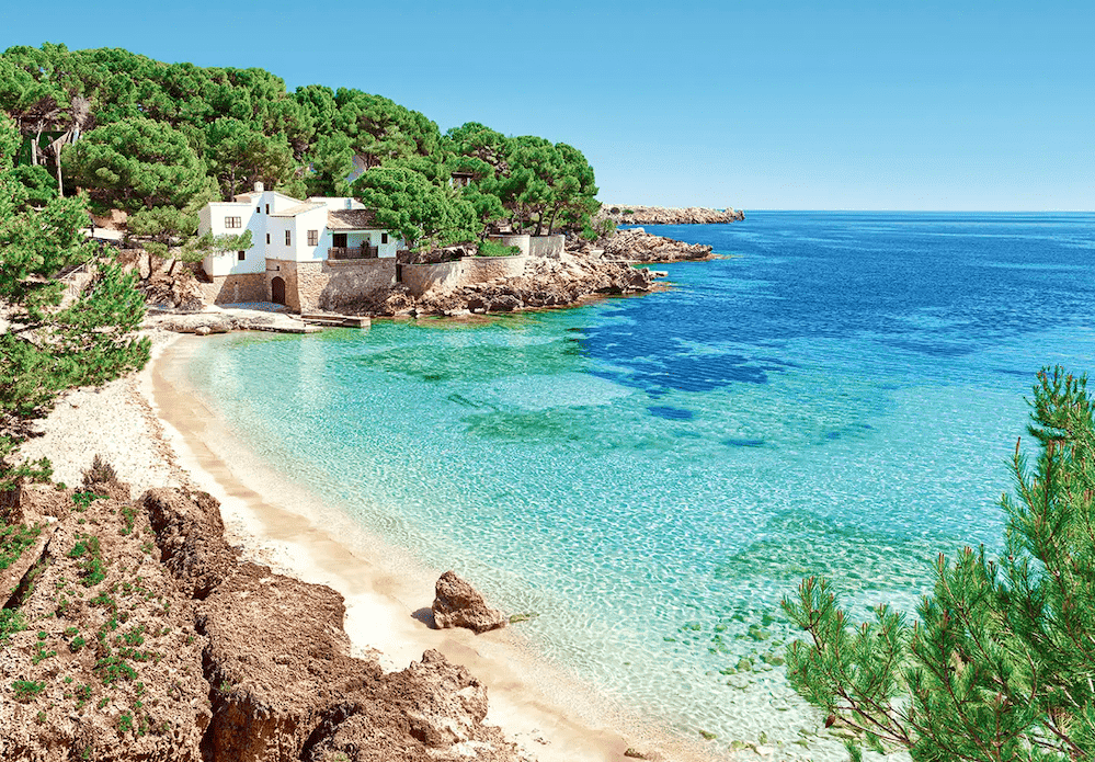 Mallorca – uvala Cala Gat s mirnim morem, pijeskom i zelenilom u pozadini